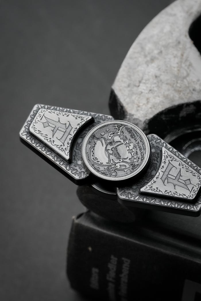 services-01 Black and white image showcasing a detailed metal spinner with engraved designs on a dark surface.